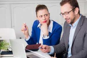 businesswoman looking confused by business man's communication